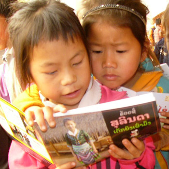 Two girls share a book about the Hmong ethnic group