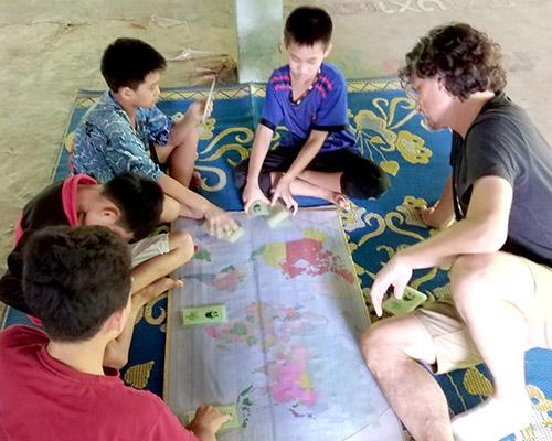 A group sitting on floor, map between them, playing a game