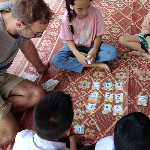Several people play a math game with numbered cards