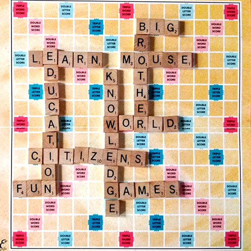 A Scrabble board with letters spelling out Big Brother Mouse, World Citizen, and other words