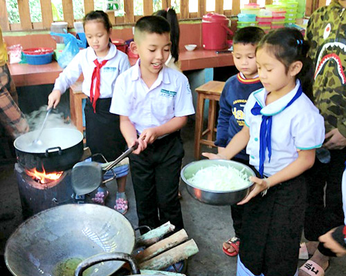 Boys and girls learn cooking skills at Big Sister Mouse school in Luang Prabang, Laos.