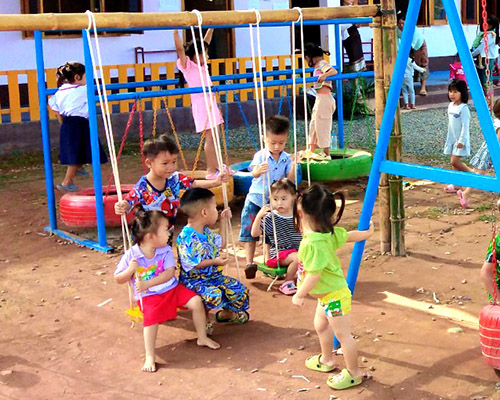 Children on a swingset at a preschool playground