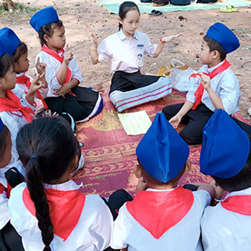 Children from Little Rabbit School in Udom Xai province teach Lao sign language to students at a nearby school