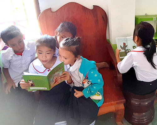 Five children reading in a small library