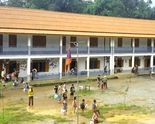 A 2-story school with children playing outside