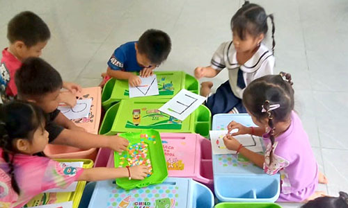 Children color shapes in the outline of letters