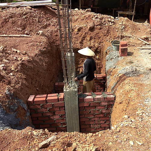 A deep foundation hole being dug for a new school in Laos.
