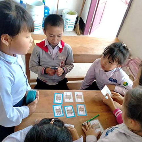 A girl at Ton Kit school in Laos teaches a new game to other students