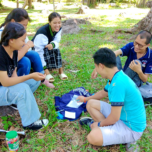 A group of young adults sitting on the grass in a park