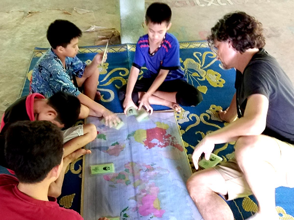 Lao schoolchildren and a visitor play a geography game