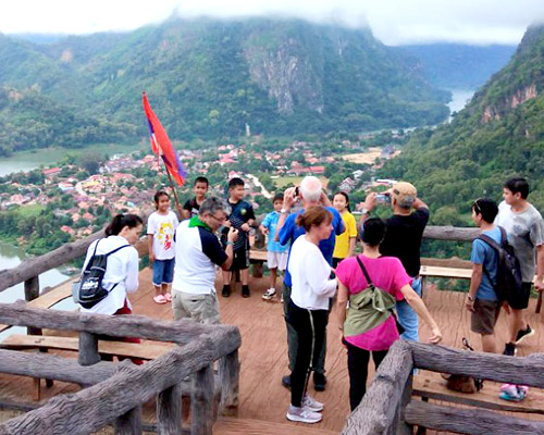 A group stands on a platform overlooking the Nam Ou river and town of Nong Khiao.